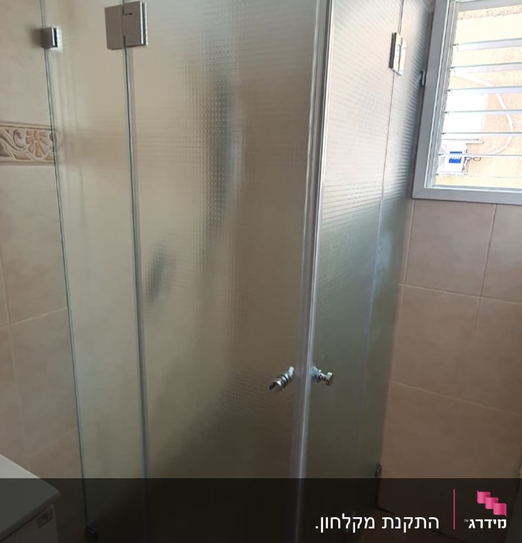 מקלחון זכוכית עם דלתות מתכת בחדר אמבטיה